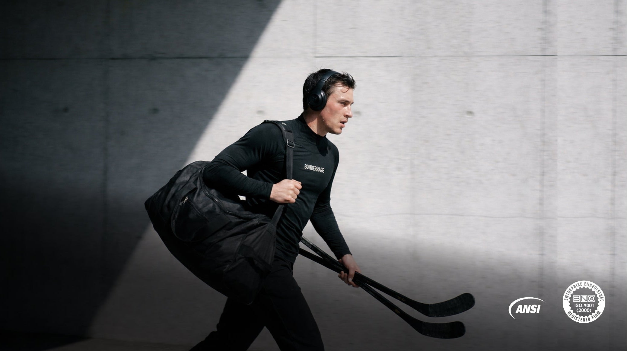 Hockey athlete wearing a Bonderkage cut-resistant base layer, carrying equipment and running through a concrete tunnel.